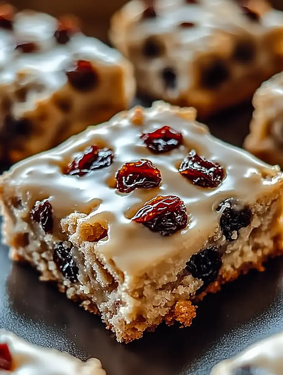 Eine Nahaufnahme eines saftigen Dessert-Quadrats mit Zuckerguss und garnierten Trockenfrüchten.